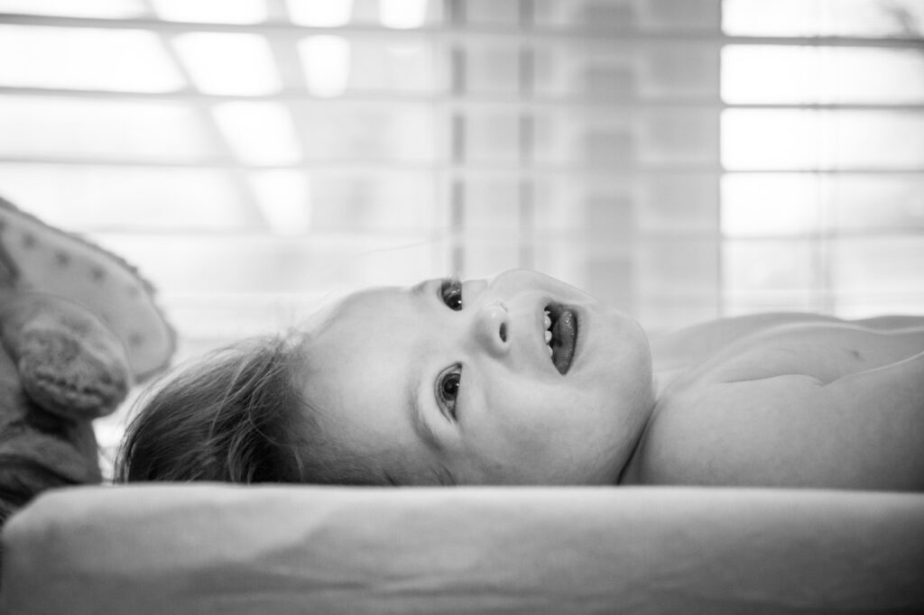 toddler boy smiling in his nursery during a photo session