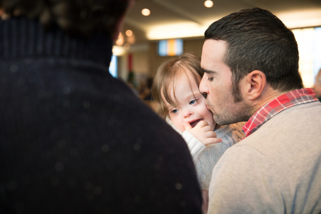 dad kissing toddler son at church