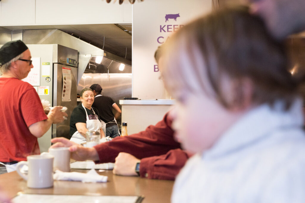 kitchen staff at diner smiling at toddler boy