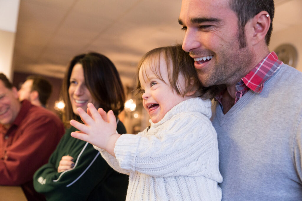toddler boy smiling with his dad inside a diner restaurant