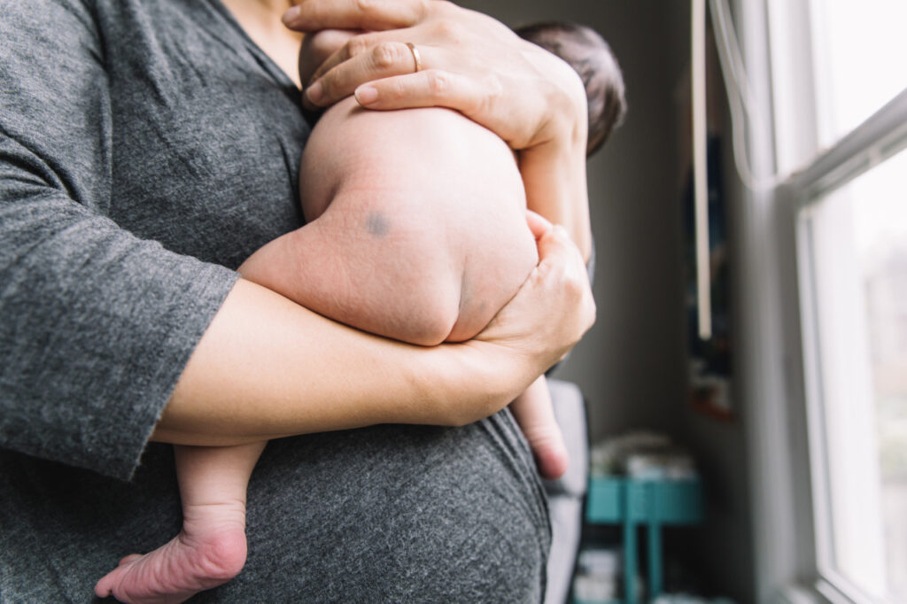 new mother holding newborn son during a family photo session in san francisco.
