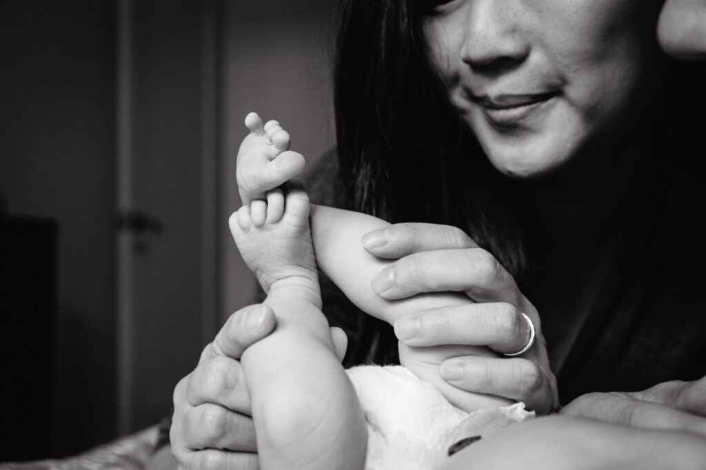 new mother holding her newborn son in the bedroom during an in-home photo session in san francisco.