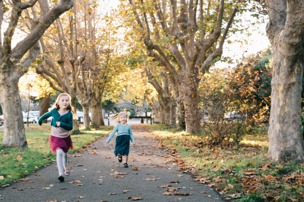 young toddler girls running at crab cove during a family photo session in alameda.