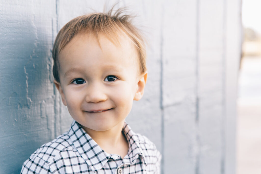 Toddler boy smiling during a family photo session at Lake Merritt Boat House in Oakland.