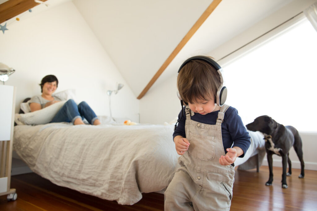 young son jamming out with headphones with mom laughing family home session sf bay area