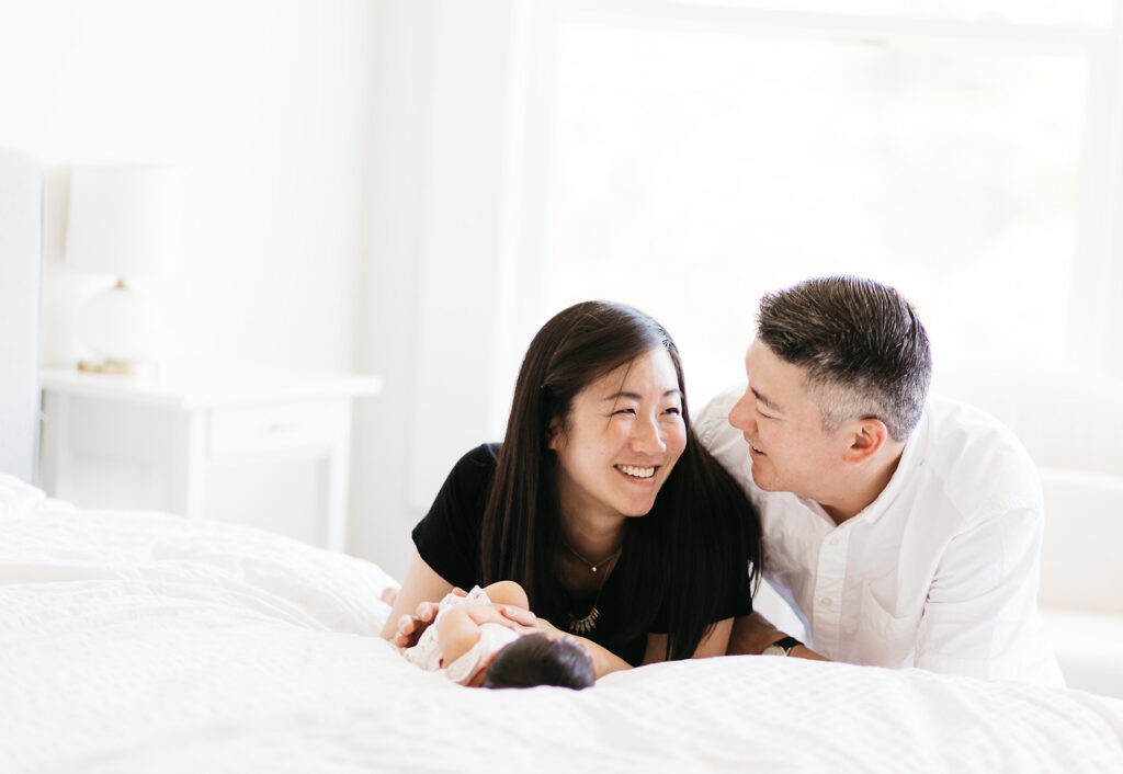 sleep deprived father and mother laughing newborn home session sf bay area
