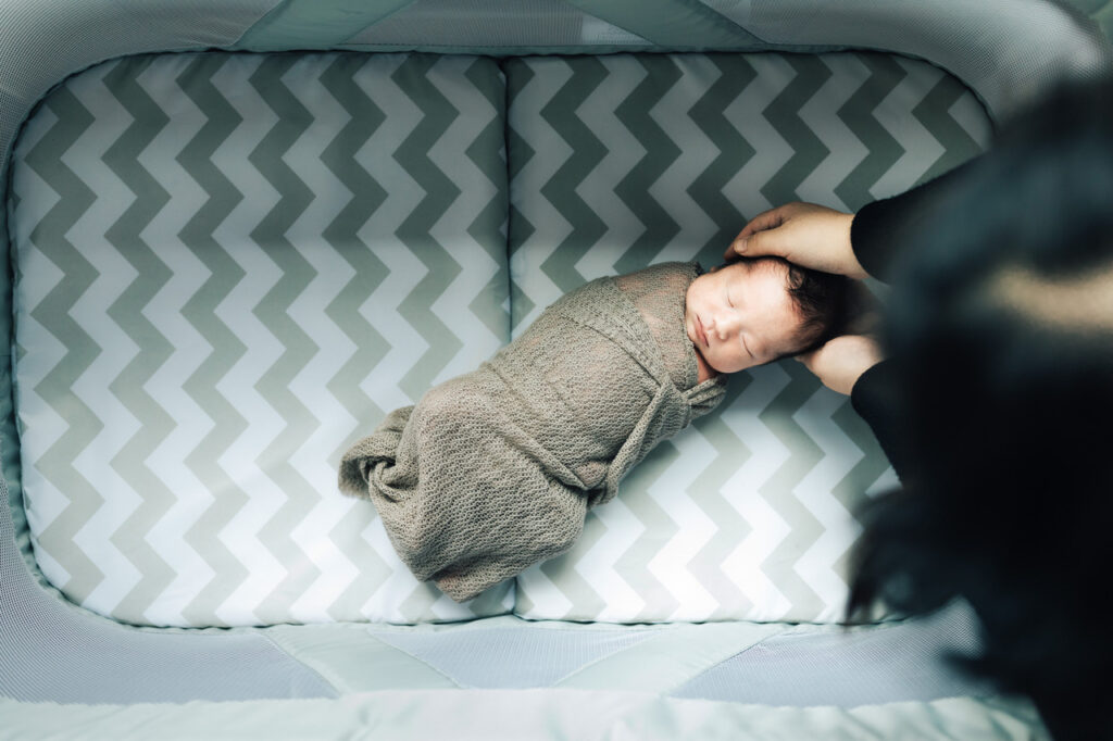 baby boy in crib nusery being held by mom newborn session sf bay area menlo park