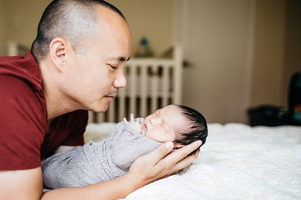 dad gazing at baby son newborn home session sf bay area