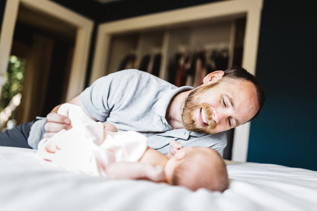 father laughing at baby daughter newborn home session bay area alameda