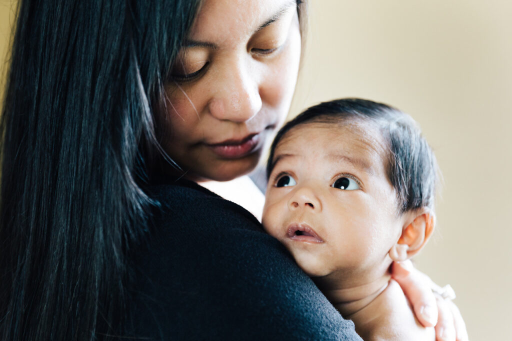 mom tenderly holding baby boy son home newborn session sf bay area