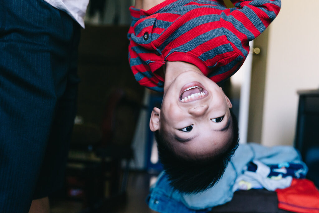 sibling brother having fun dangling upside down home newborn session sf bay area
