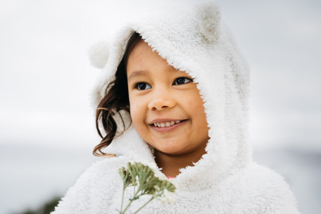 san-francisco-bay-area-family-photographer-carmen-dunham-photography-and-filmsIMG_7017-2 portrait of girl in teddy bear hoodie smiling and holding flower