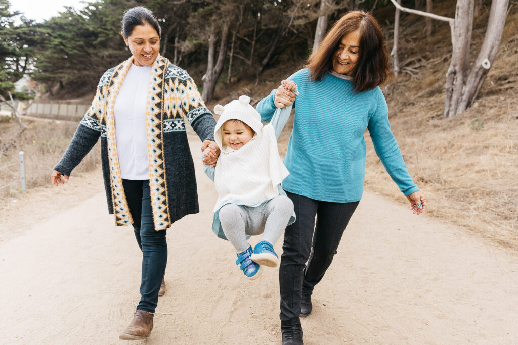san-francisco-bay-area-family-photographer-carmen-dunham-photography-and-filmsIMG_7948-2 three generations of a family having fun swinging girl by the arms at lands end san francisco