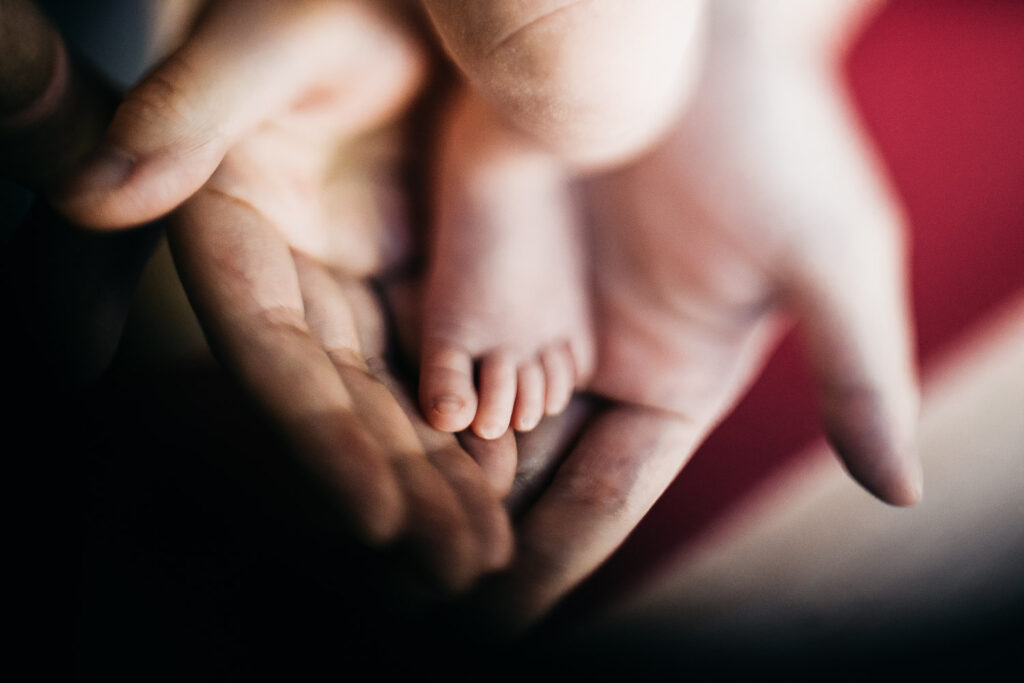 freelensed baby feet with big father's hands