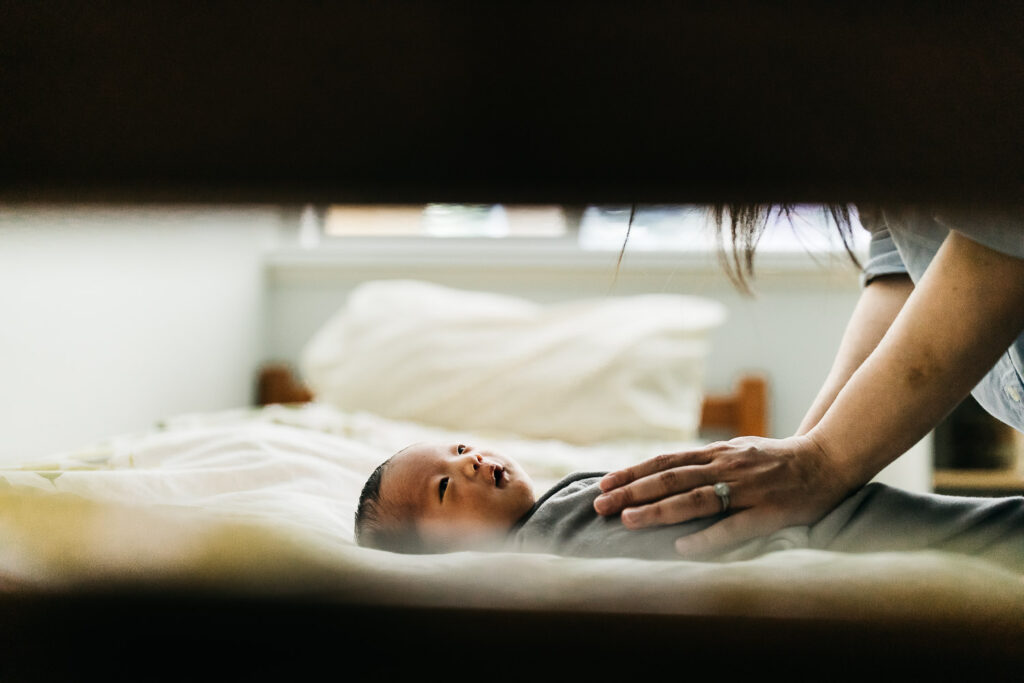newborn baby girl gazing at mother in bed
