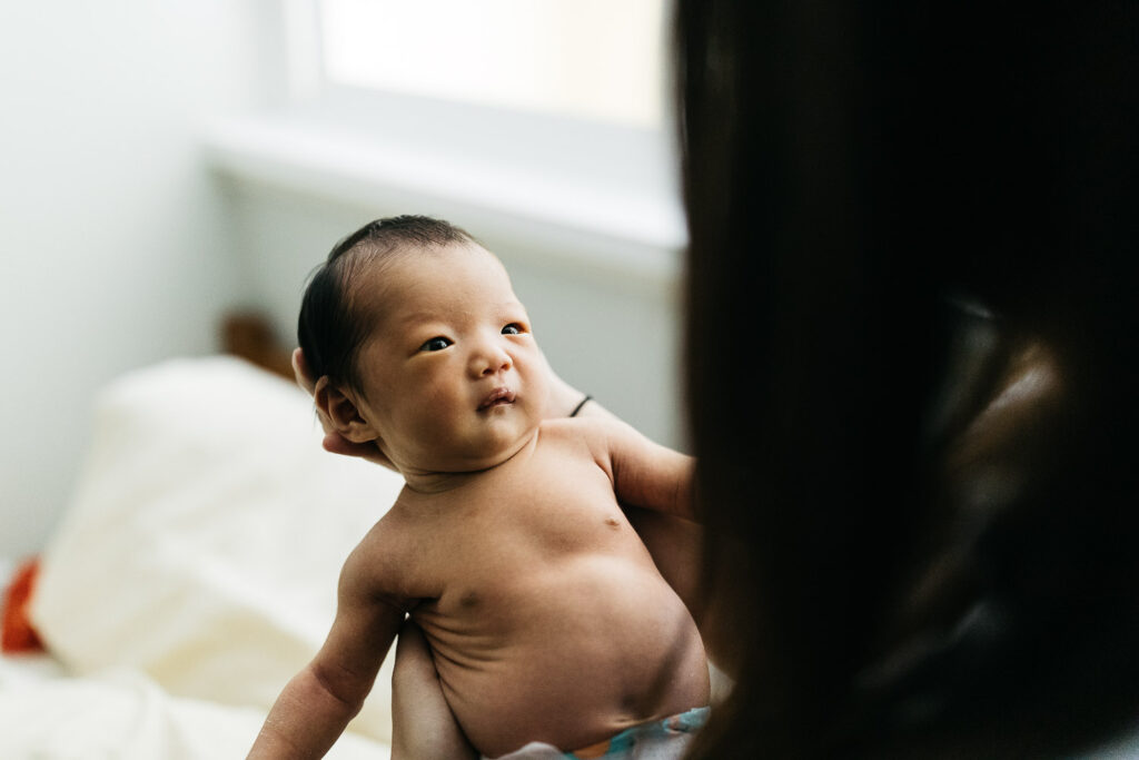 newborn baby girl gazing at her mother