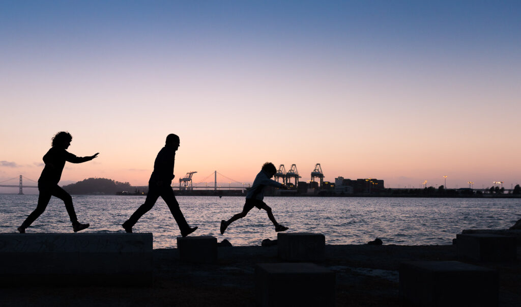 family silhouette at middle harbor shoreline park oakland during sunset