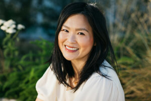 Woman is smiling among a backdrop of flowers during a creative headshot session in san francisco.