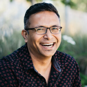 Man is smiling at the camera during an outdoor branding headshot session.