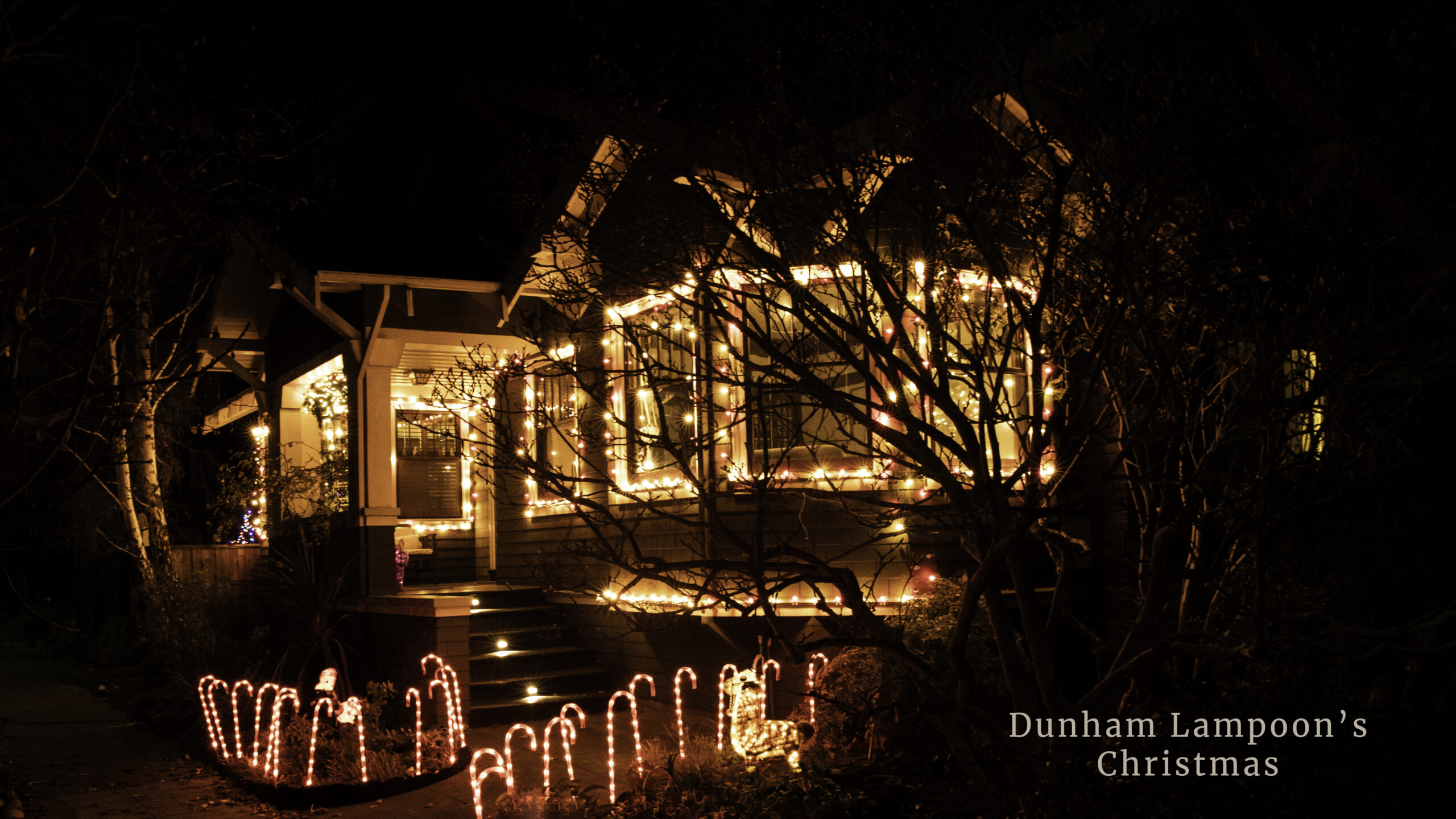 craftsman home lit up with red and white holiday nights at night
