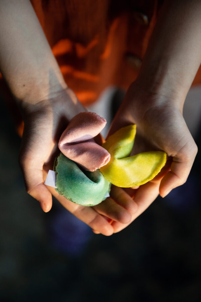 girl holding colorful array of fortune cookies