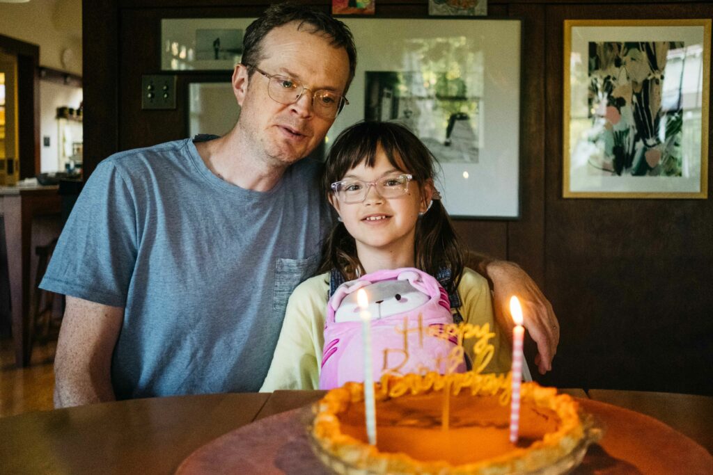father and daughter in front of birthday cake