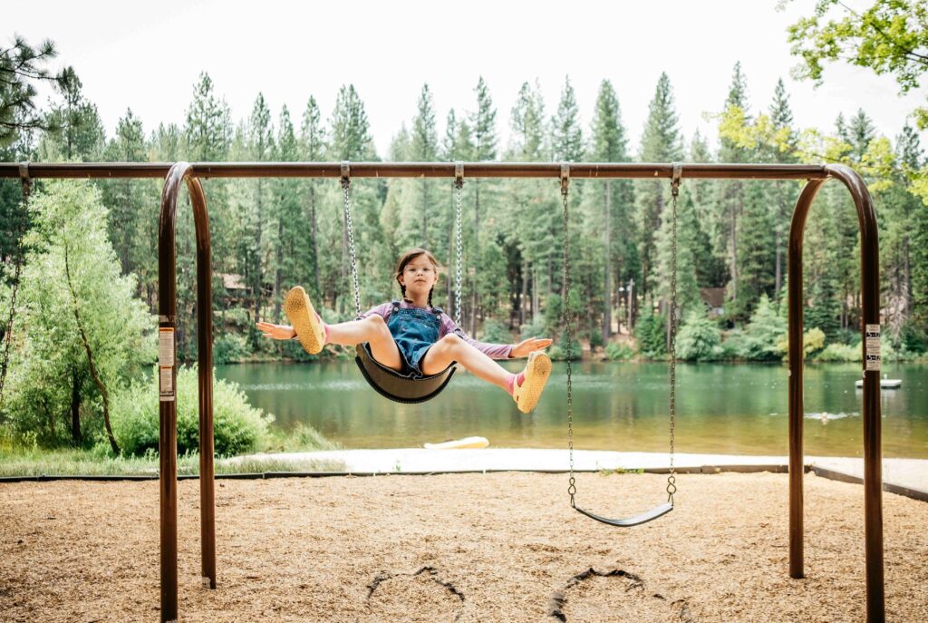 girl having fun on swings in arnold california near lake