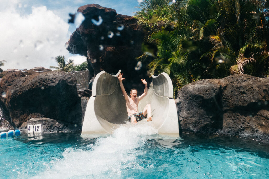 dad having fun on waterslide at koloa landing in kauai