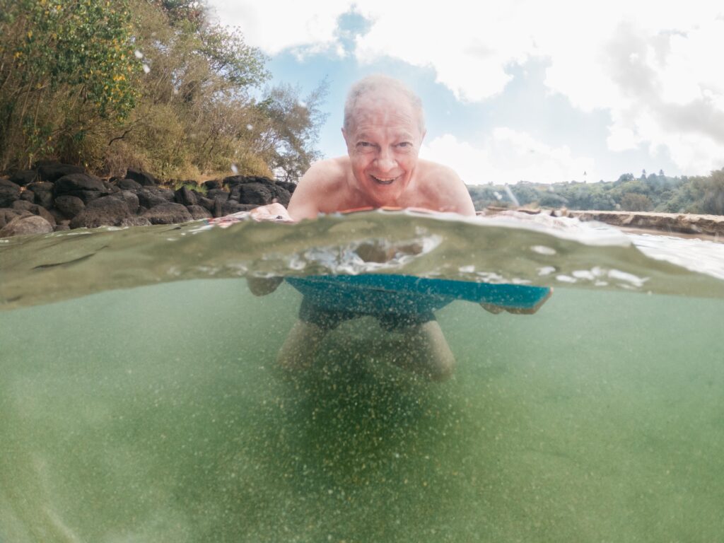 grandpa having fun with boogie board in kauai
