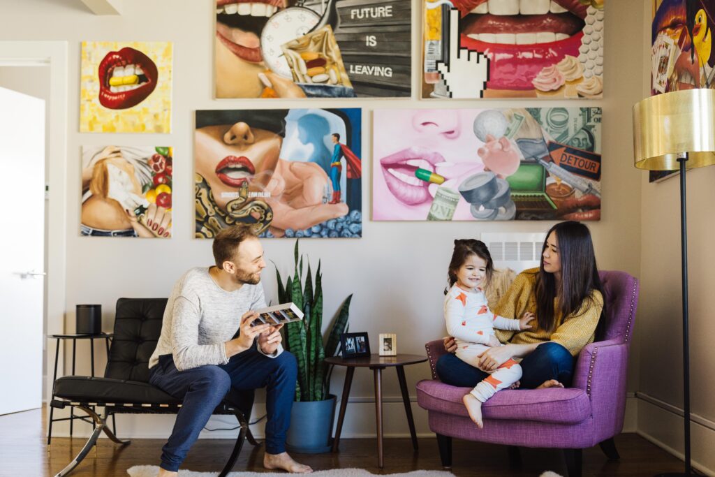 family chilling in the living room of their san francisco apartment with artwork hanging on wall