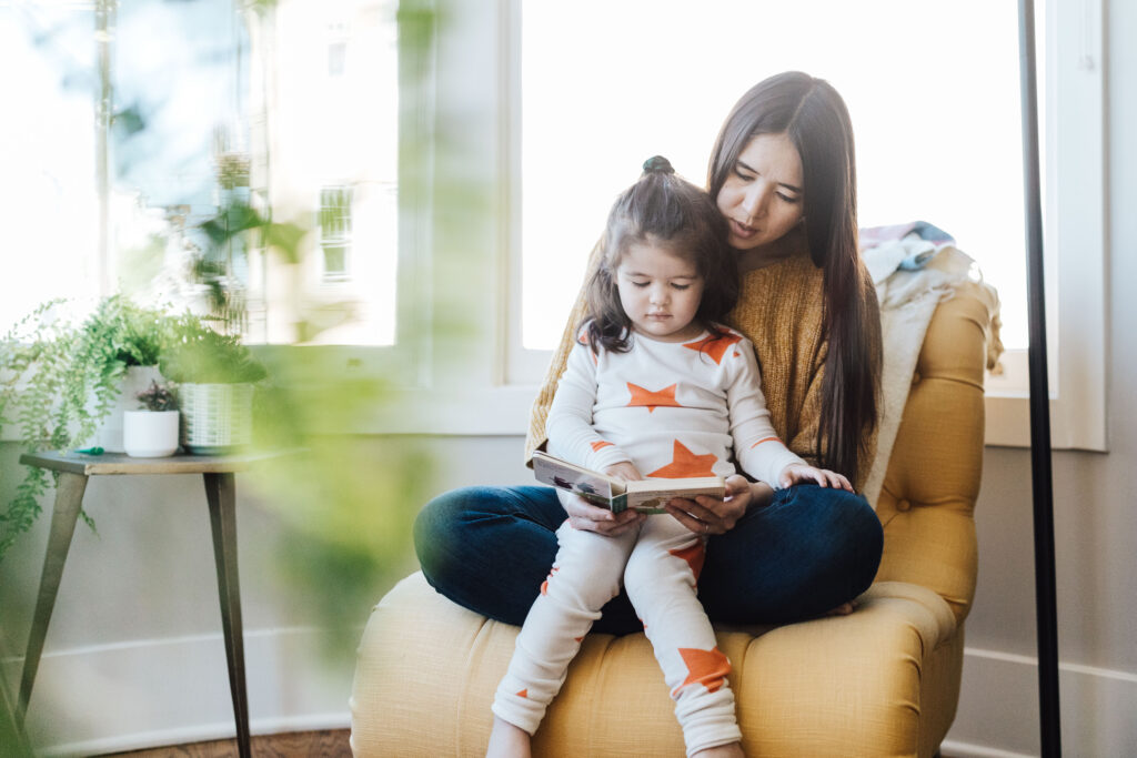 mother and daughter reading together in a chair