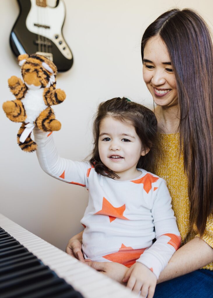 mother and daughter playing around on the piano
