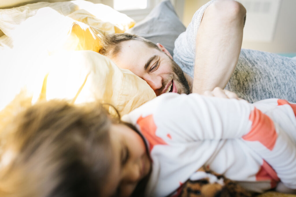 dad and daughter being goofy in the bed