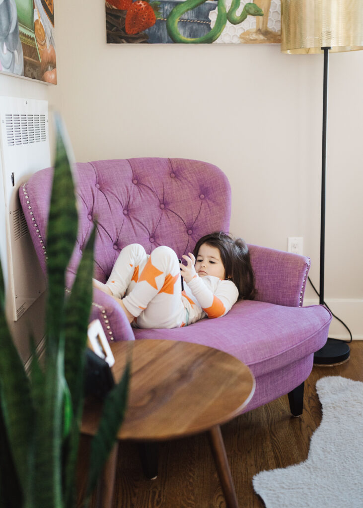toddler girl reading in her favorite chair