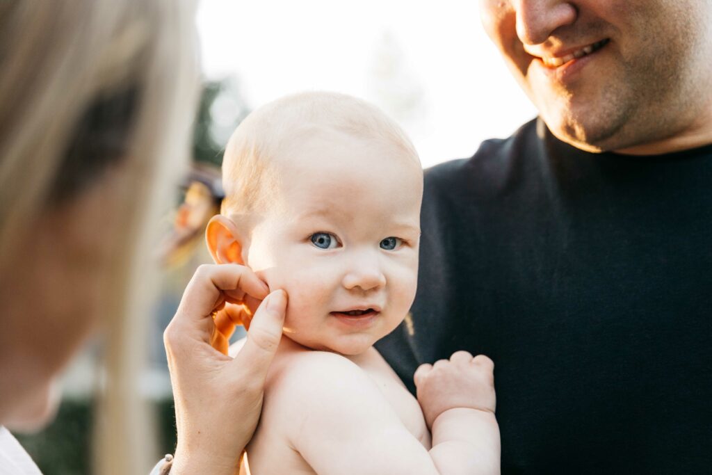 young baby being coy while in dad's arms.