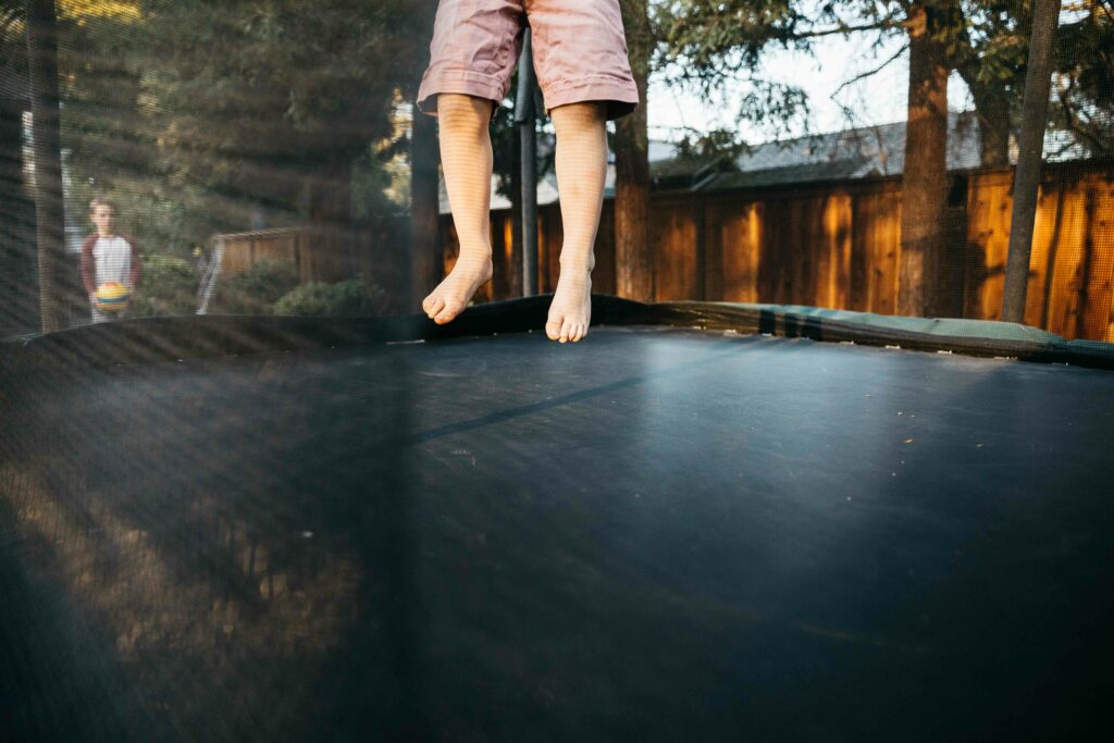 young boy's feet in mid jump on trampoline.