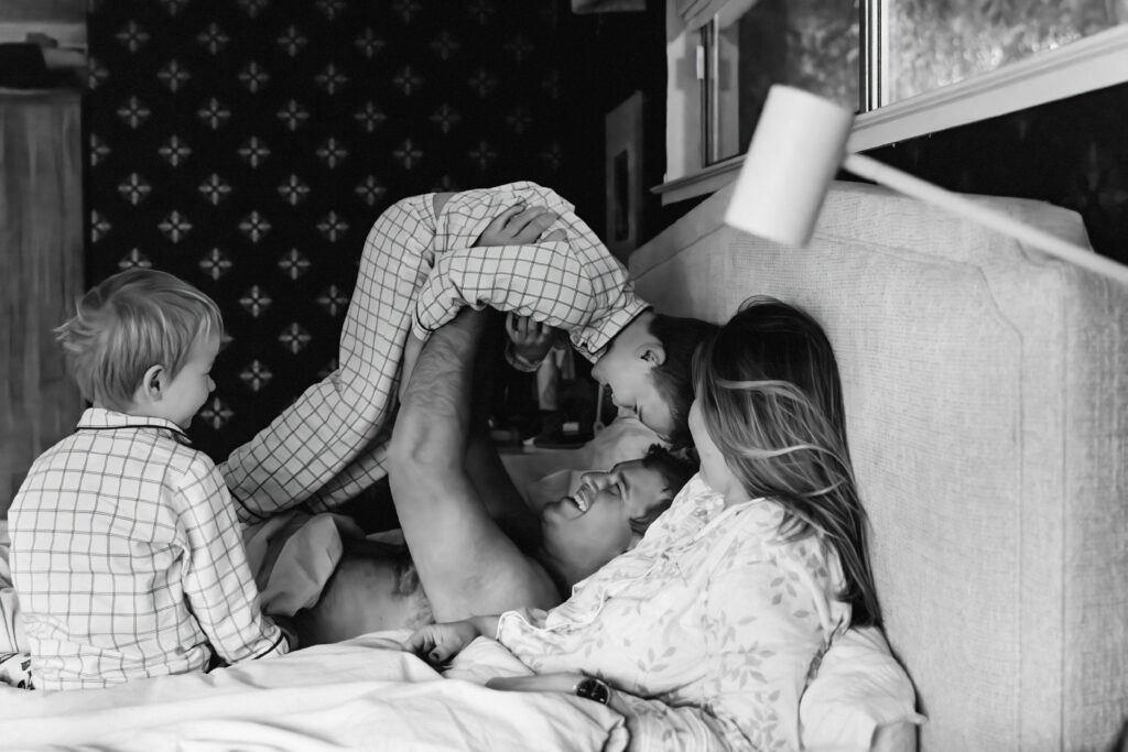 dad tossing son in bed with the rest of the family.