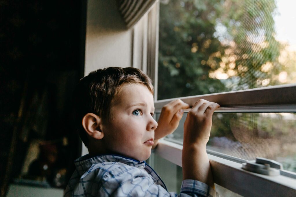 boy being goofy at the window with funny expression.