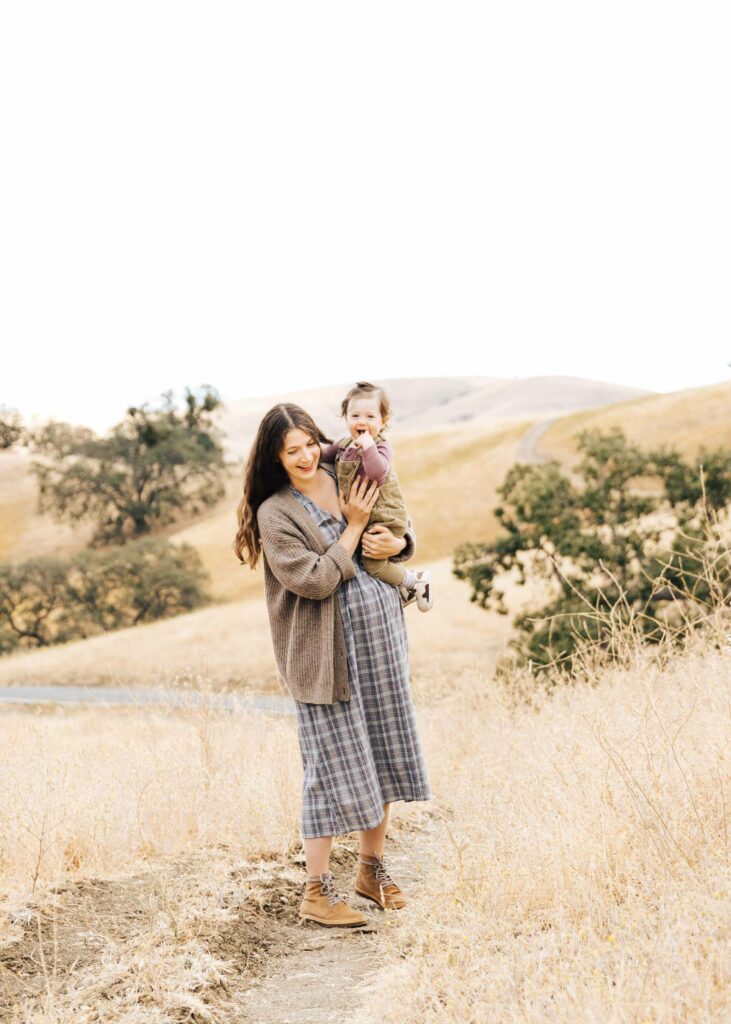 east-bay-family-photographer-IMG_0029-carmen-dunham-photography Pregnant mother holding young daughter on a grassy trail in Walnut Creek