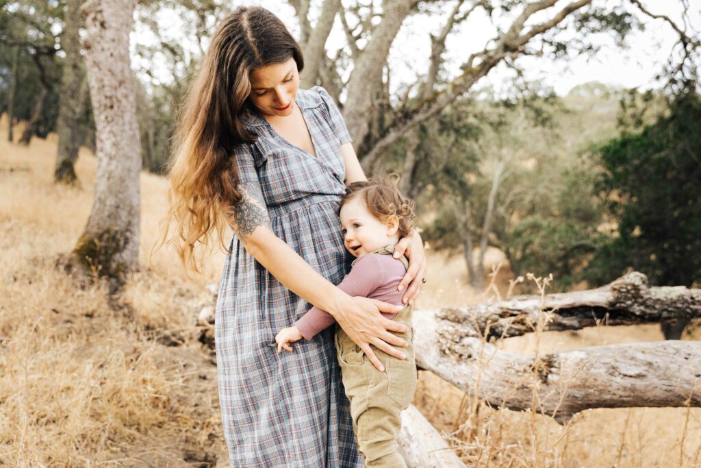 east-bay-family-photographer-IMG_0134-carmen-dunham-photography Pregnant mother holding young daughter in the tall grass at Old Borges Ranch