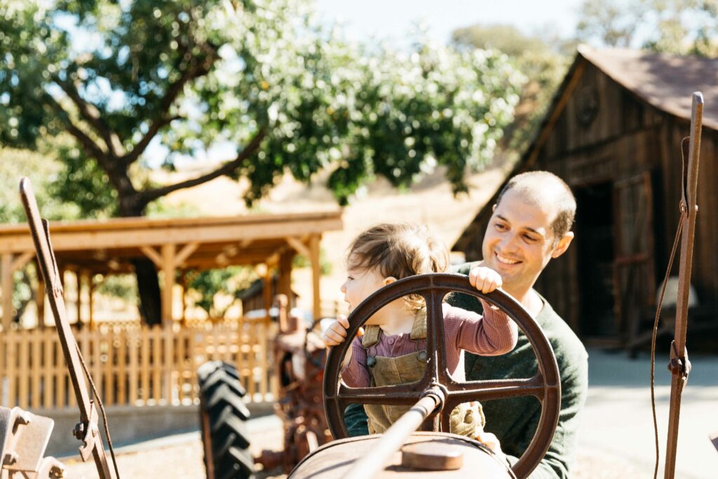 east-bay-family-photographer-IMG_0538-carmen-dunham-photography young girl on a tractor with dad at Borges Ranch.