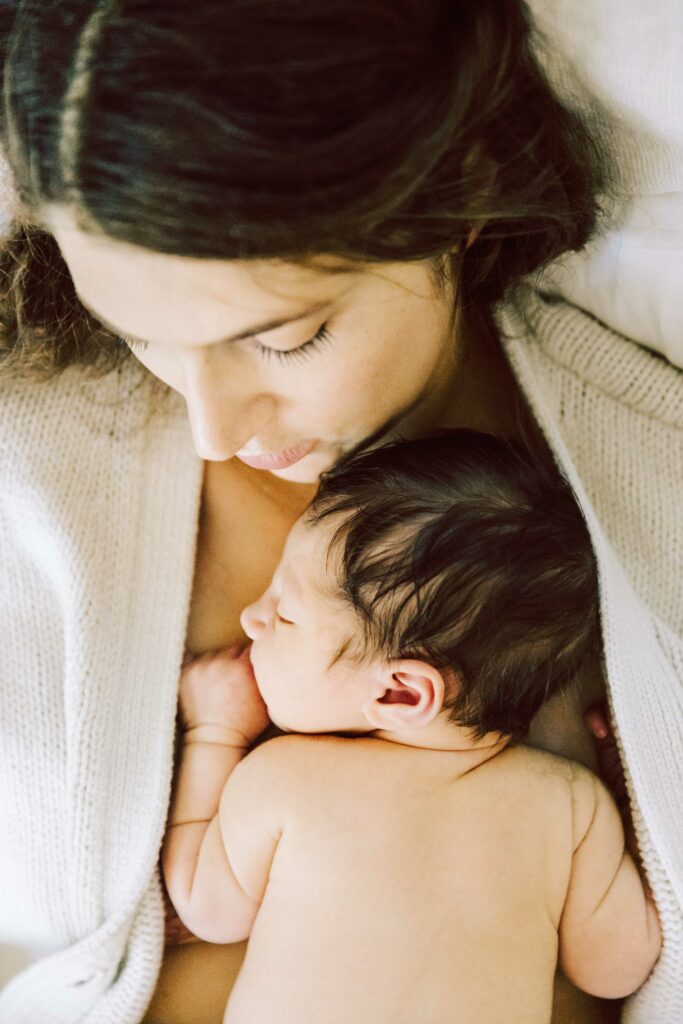 mother holding three day old baby on her chest while he sleeps