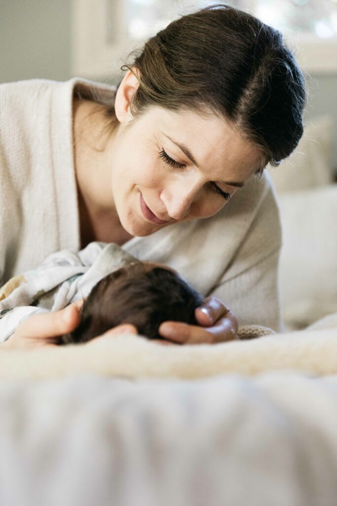 mother looking at her baby boy while he sleeps