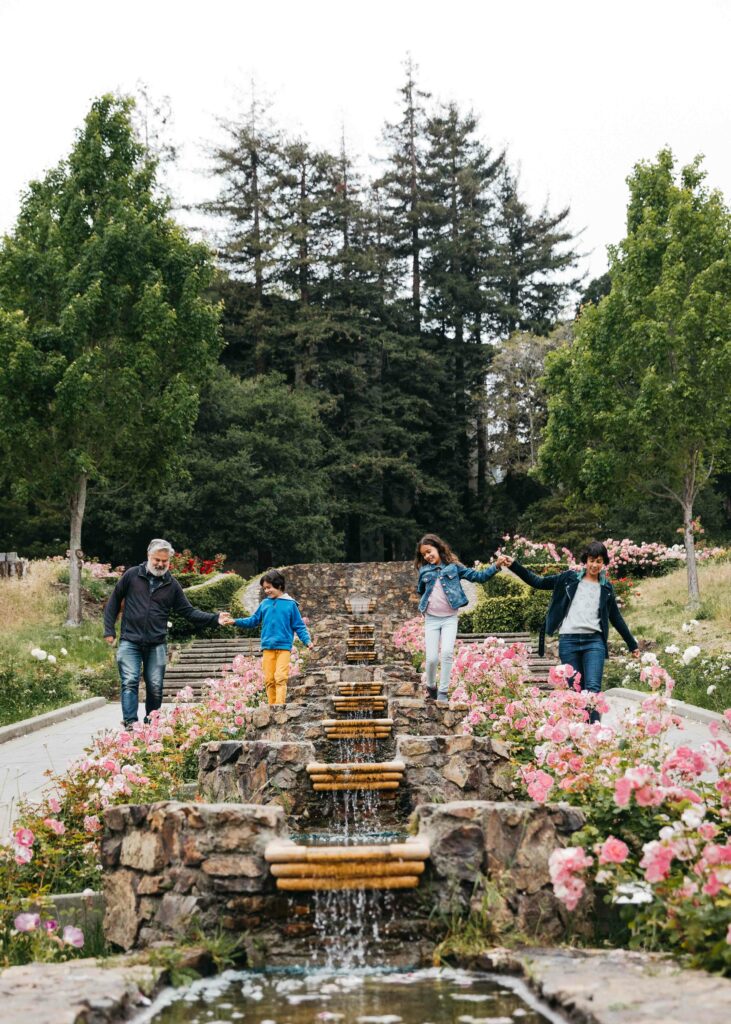 Family walking down the tiered fountain hand in hand at the Morcom Rose Garden.