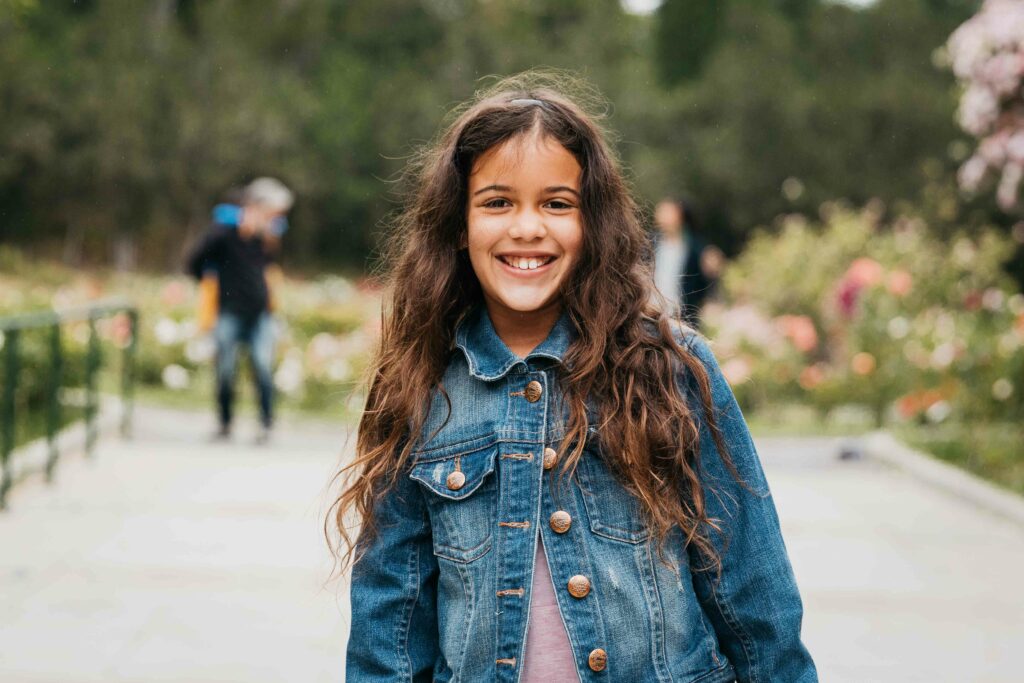 Young girl smiling at the Morcom Rose Garden.