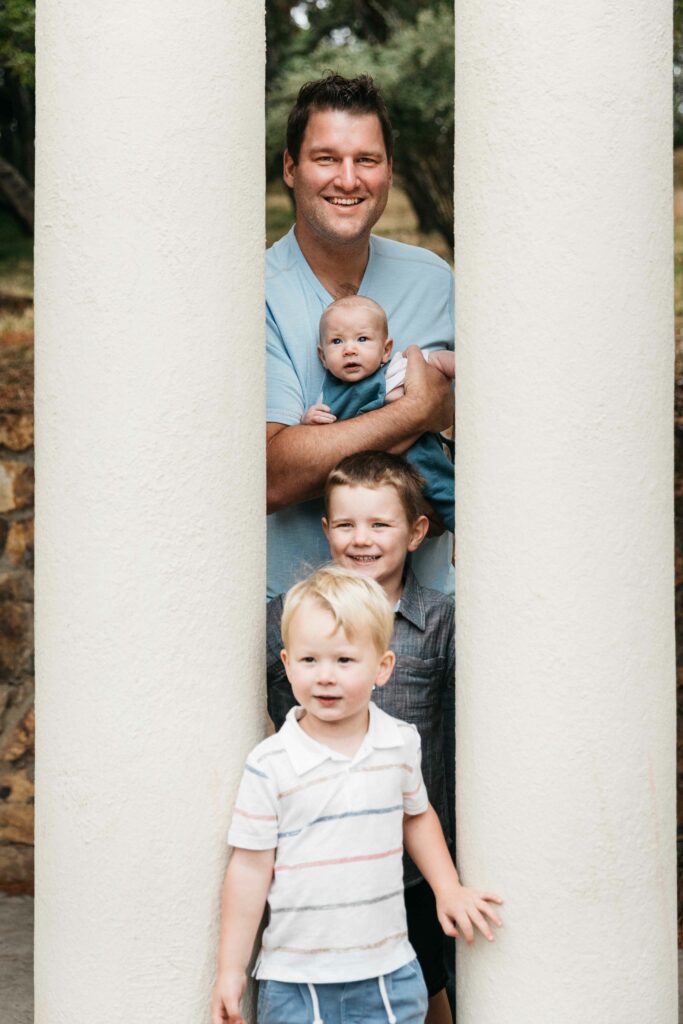 Father and sons posing at the pillars in the Morcom Rose Garden