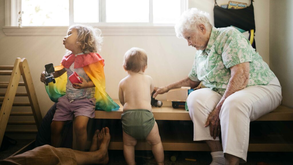 Grandma playing with her young grandchildren in the playroom during a family photo and video session in sunnyvale, ca