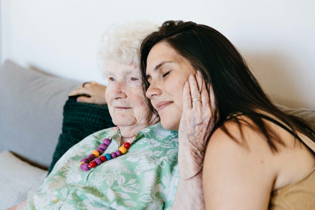 Grandmother holding the cheek of adult granddaughter