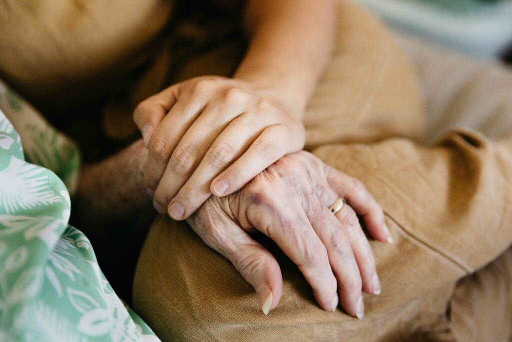 Adult granddaughter holding grandma's hand