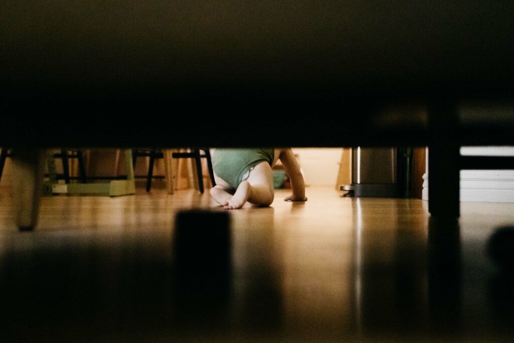 toddler boy crawling on the hardwood floors during a family in-home film and photo session